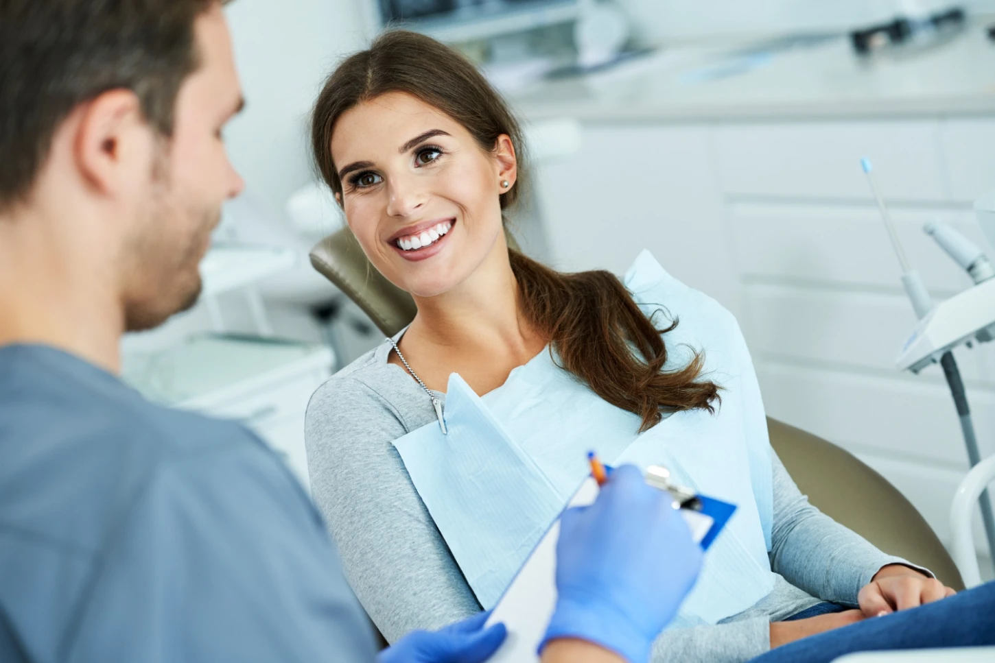 Smiling woman being attended by a dentist.